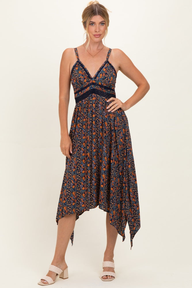 woman wearing a navy blue floral print sundress with a high-low hem and lace detailing, posing confidently
