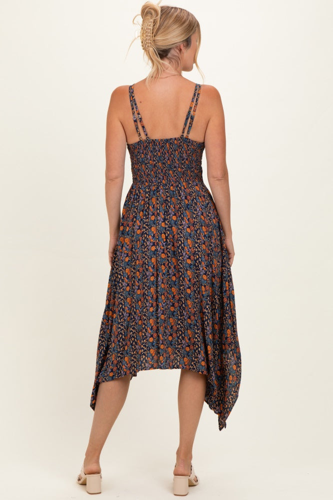 woman wearing a navy floral print maxi dress with a smocked bodice and asymmetrical hem, viewed from the back
