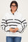 woman wearing a white and black striped pullover sweatshirt with a high collar and button detailing, smiling and wearing glasses