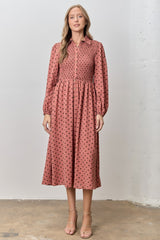 woman wearing a dusty rose button-up midi dress with polka dots and smocked waist, standing against a neutral background