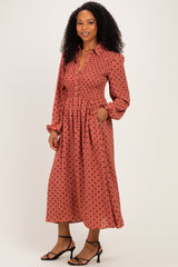 woman wearing a rust polka dot long sleeve dress with a smocked waist and pockets, styled with strappy heels
