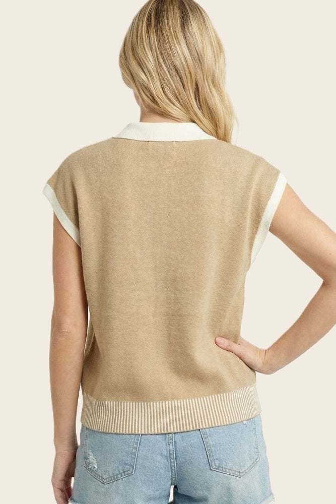 woman wearing a tan short sleeve sweater with a white collar and ribbed hem, seen from the back