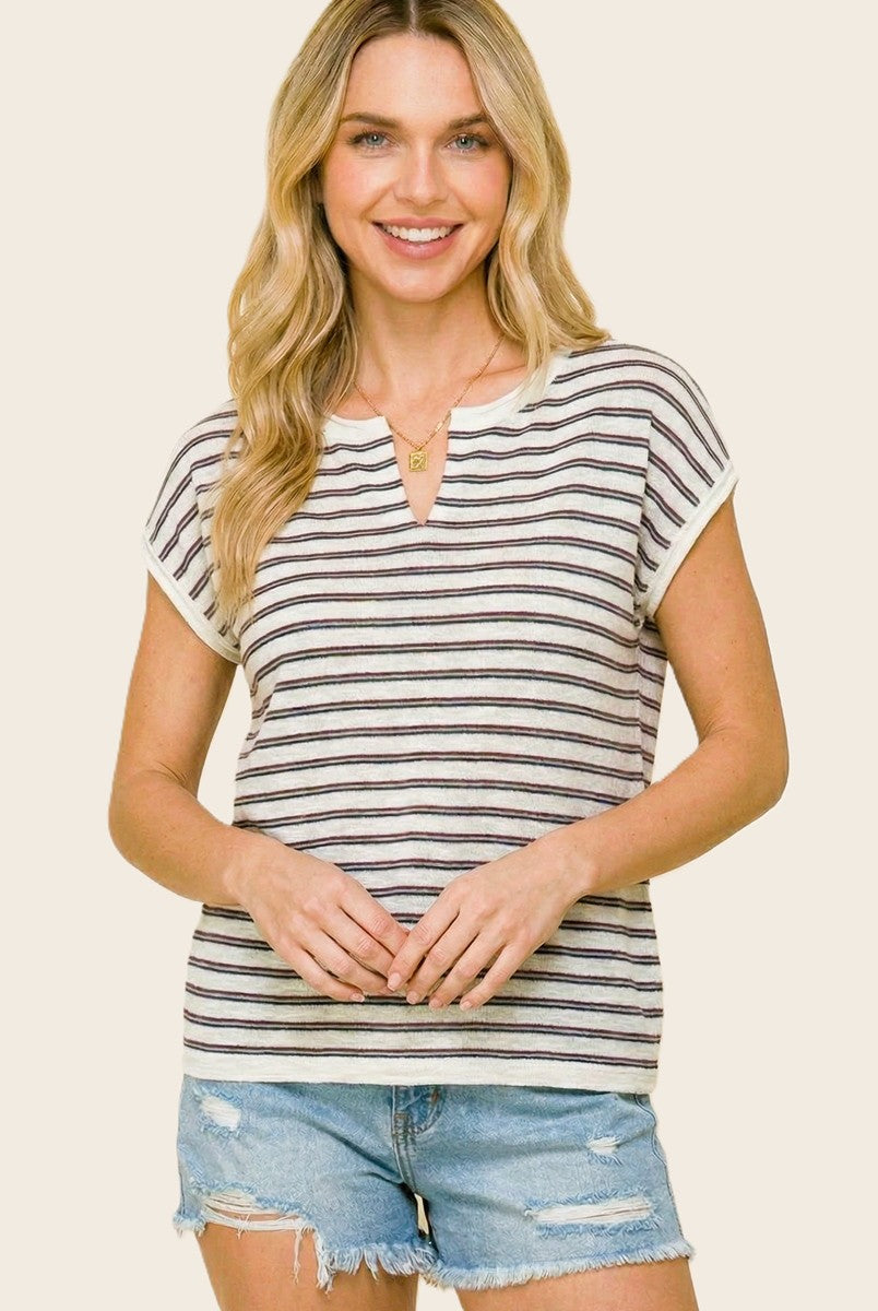 woman wearing a striped short sleeve top with a v-neckline and distressed denim shorts