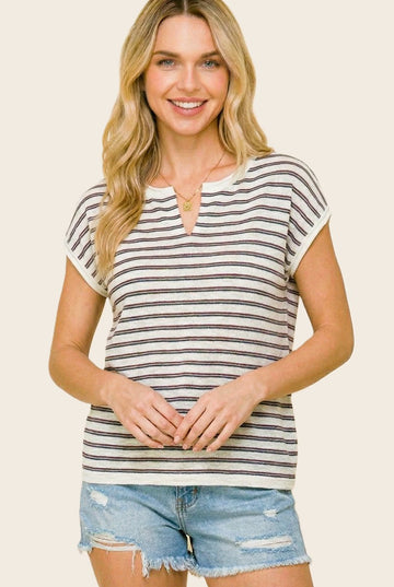 woman wearing a striped short sleeve top with a v-neckline and distressed denim shorts