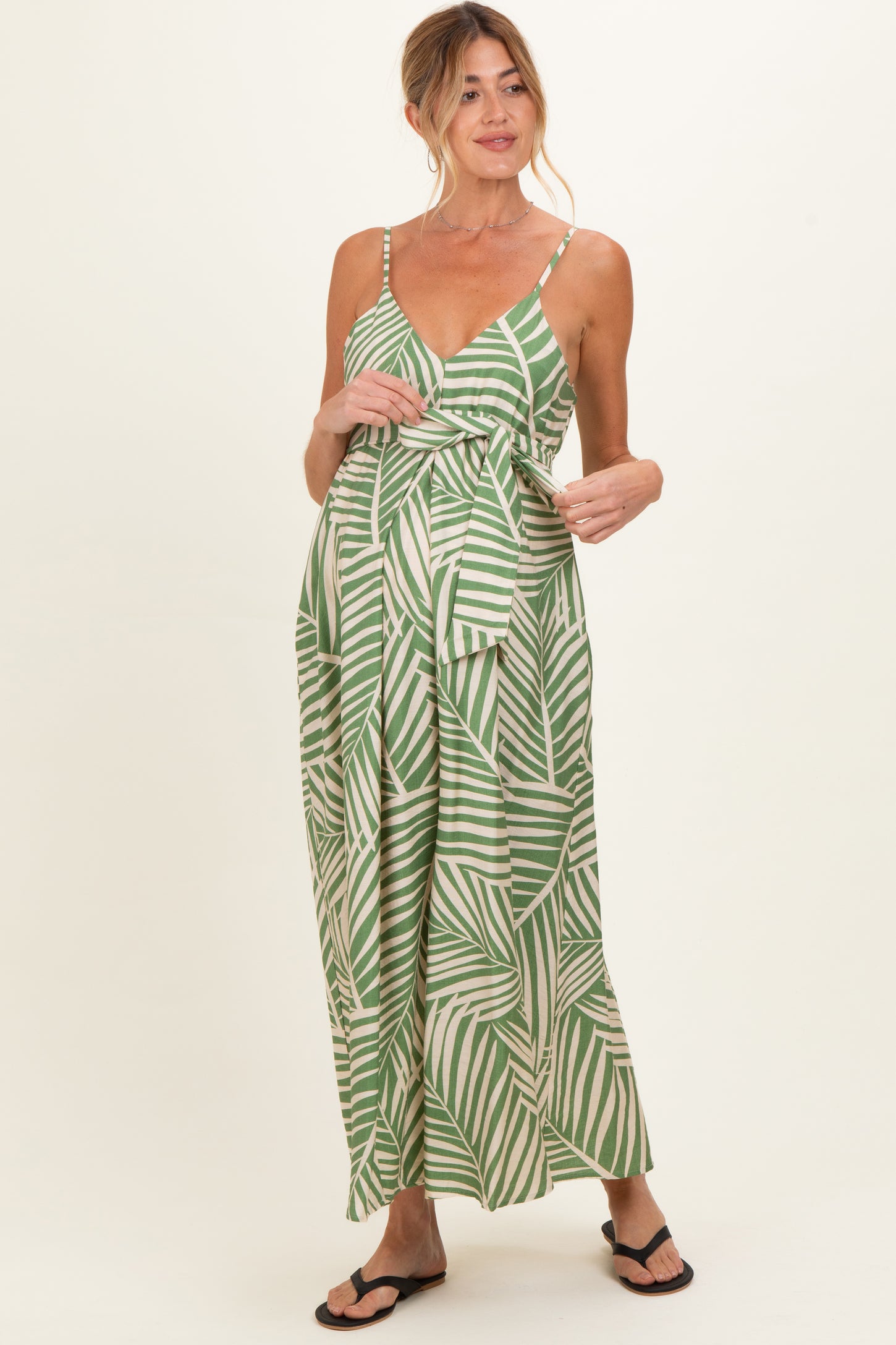 woman wearing a green and white striped maternity maxi dress with a tie front detail and a visible baby bump