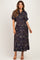 woman wearing a dark floral maternity dress with short sleeves and a fitted waist, showcasing her baby bump