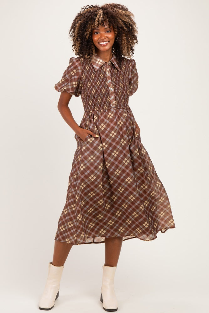 woman wearing a brown plaid maternity dress with short sleeves and pockets