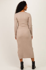 woman wearing a ribbed beige maternity dress with long sleeves and a fitted silhouette, showing a baby bump from the back