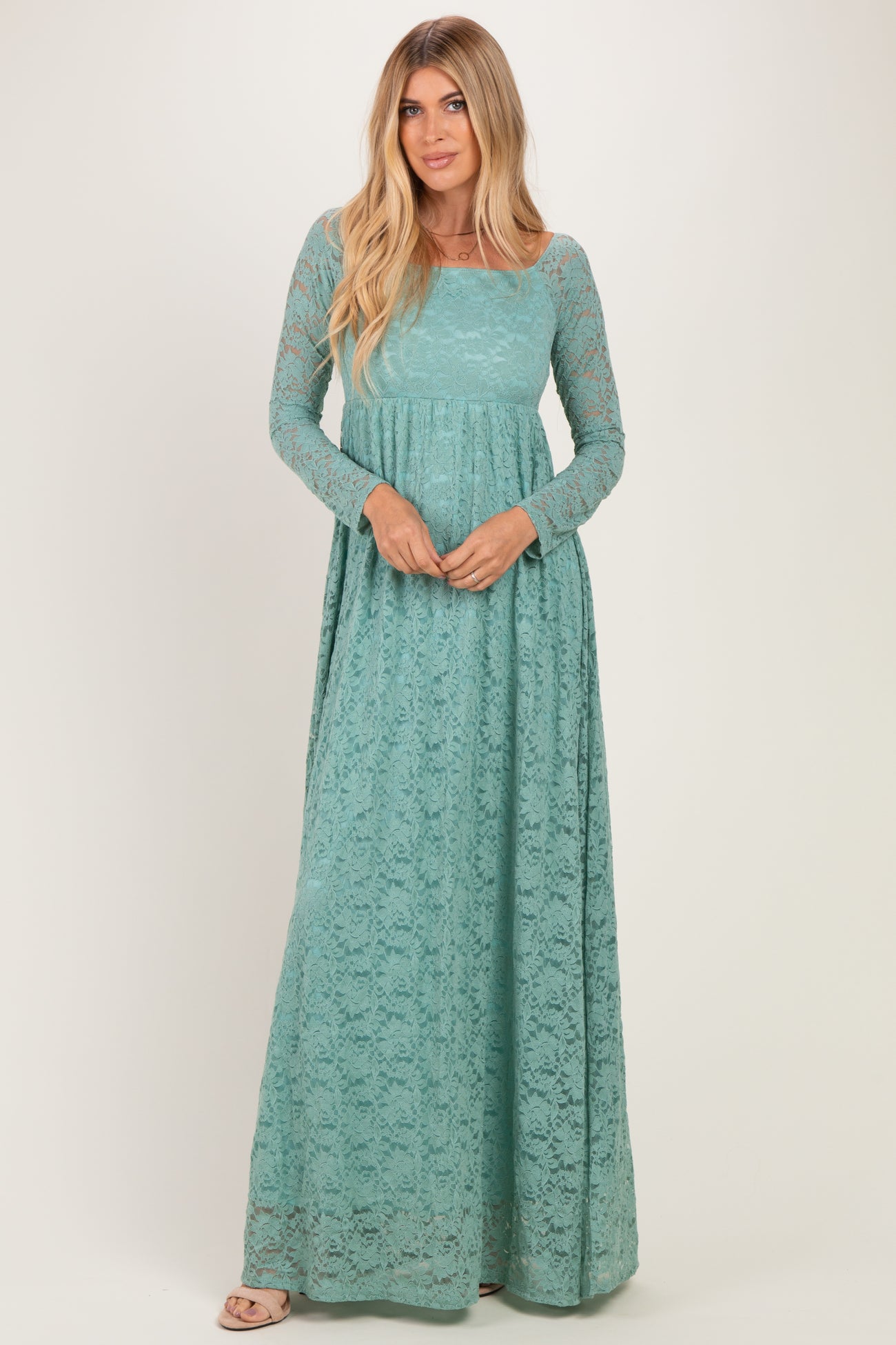 woman wearing a teal long sleeve lace maxi dress with a fitted bodice and flowing skirt
