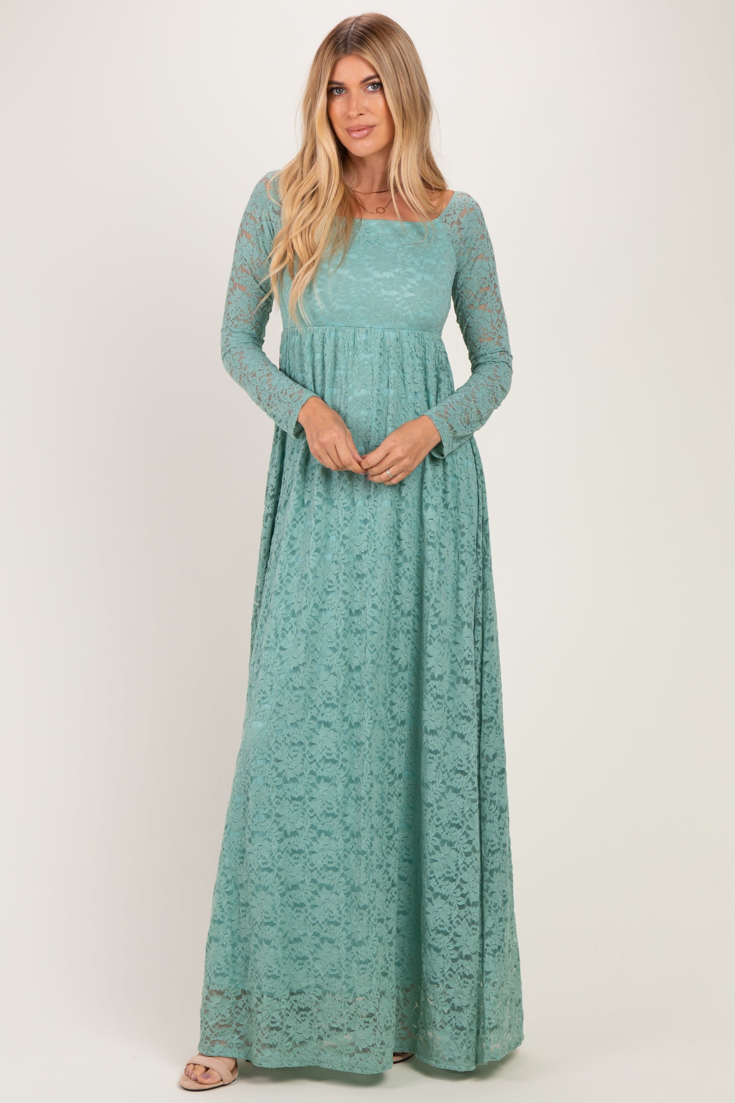 woman wearing a teal long sleeve lace maxi dress with a fitted bodice and flowing skirt