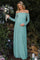 woman wearing a mint green off-shoulder lace maternity dress holding a bouquet and showing her baby bump