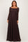 woman wearing a long sleeve dark brown lace maxi dress with a fitted bodice and flowing skirt