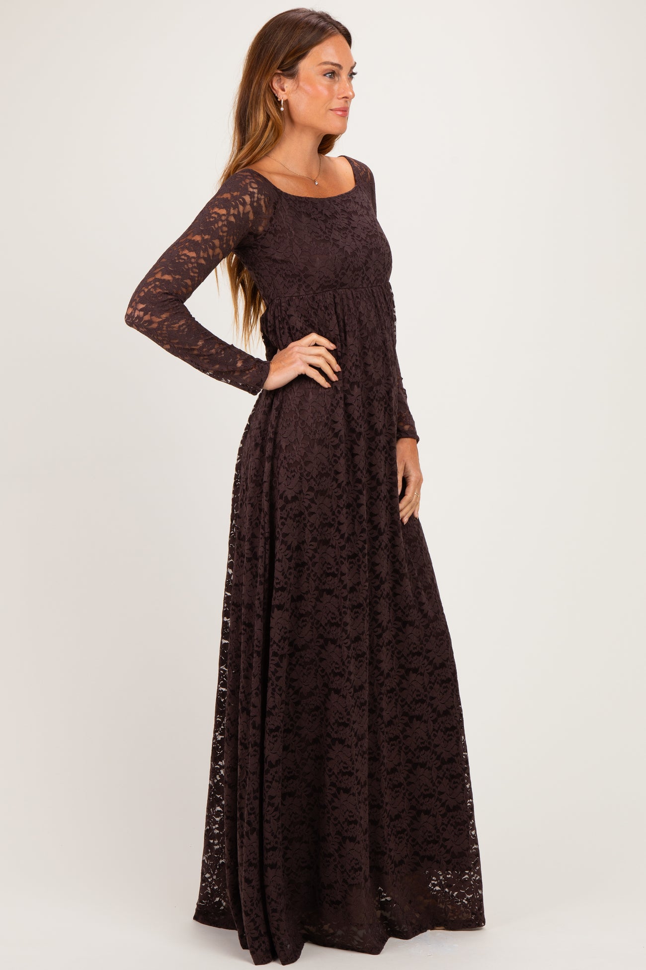 woman wearing a long sleeve burgundy lace maxi dress with a fitted bodice and flowing skirt