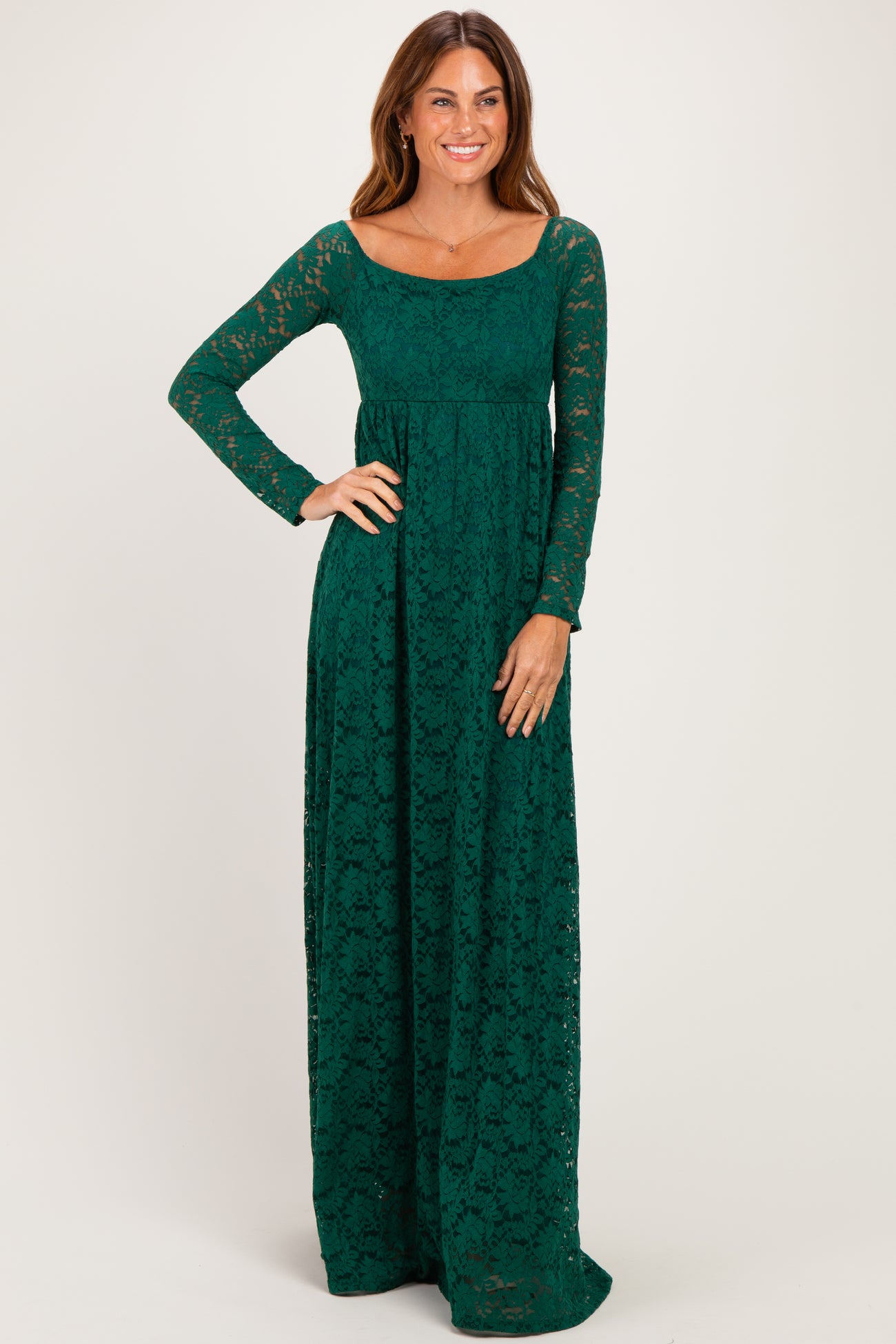 woman wearing a dark green long sleeve lace maxi dress with a scoop neckline and fitted waist