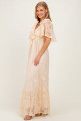 woman wearing a beige lace maxi dress with ruffle details and short flutter sleeves