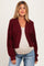 woman wearing a burgundy lightweight maternity cardigan over a beige top and showing her baby bump with relaxed fit jeans
