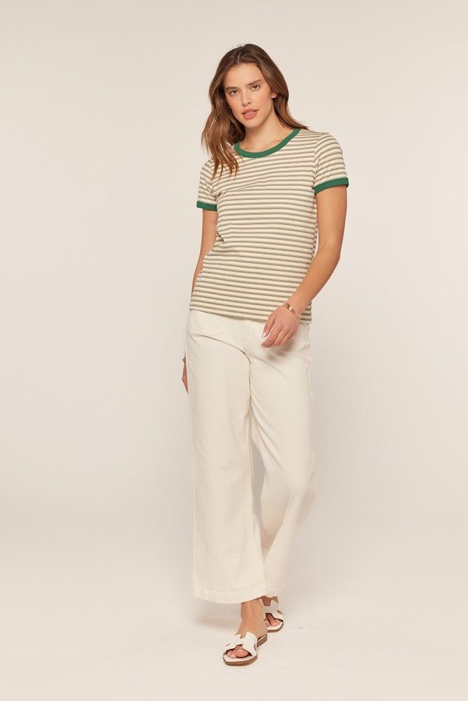 woman wearing a tan and green striped t-shirt with green ribbed neckline and white wide-leg pants