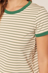 woman wearing a cream striped t-shirt with green trim and short sleeves