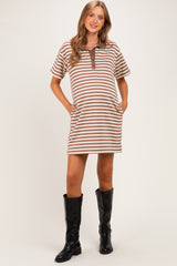 woman wearing a striped brown and cream maternity dress with a button placket and pockets, styled with black knee-high boots
