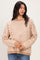 woman wearing a beige and white striped oversized sweater with long sleeves and a relaxed fit