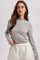 woman wearing a gray and white striped long sleeve top with a round neck and a relaxed fit