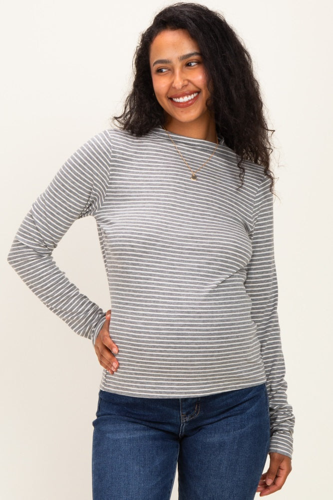 woman wearing a gray and white striped maternity long sleeve top and smiling with a visible baby bump