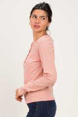 woman wearing a light pink and white striped long sleeve top with buttons on the front