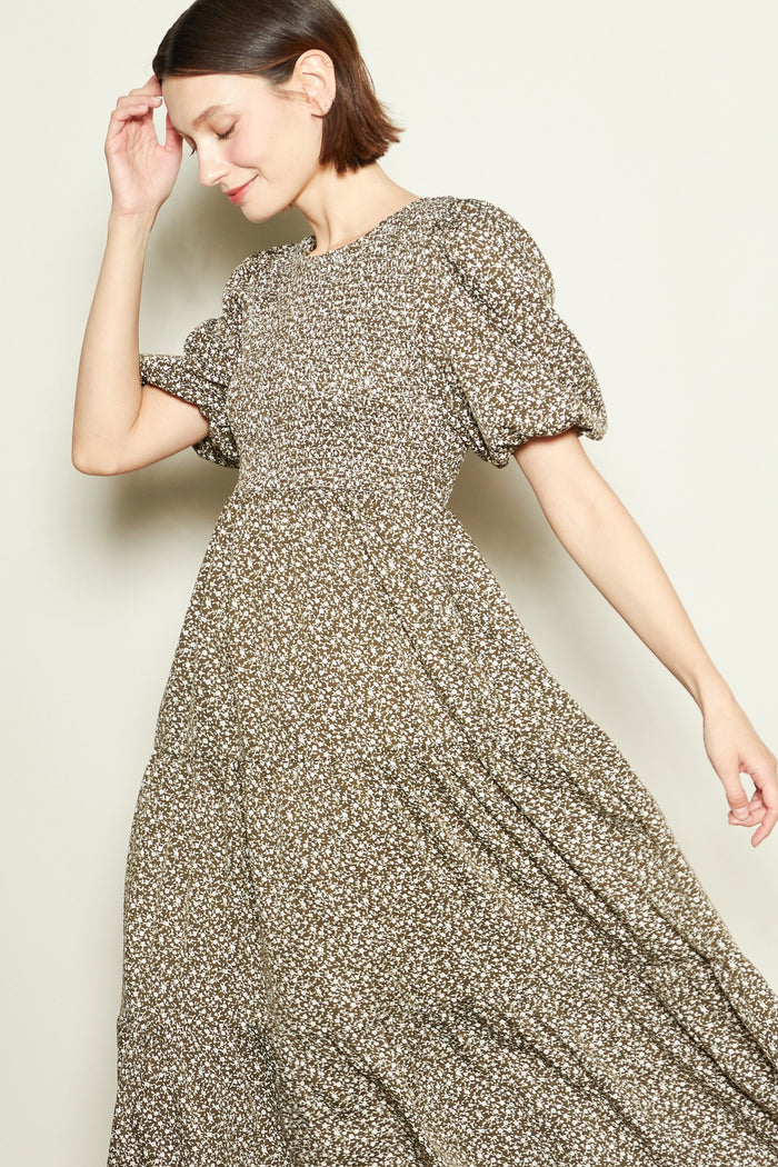 woman wearing a brown floral puff sleeve maxi dress with a flowing skirt