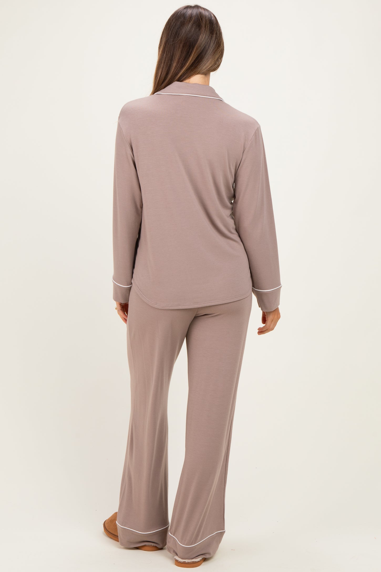 woman wearing a light brown maternity pajama set with a long sleeve top and wide-leg pants, showing a relaxed fit from the back