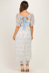 woman wearing a light blue lace maternity dress with short puff sleeves and a bow detail at the back
