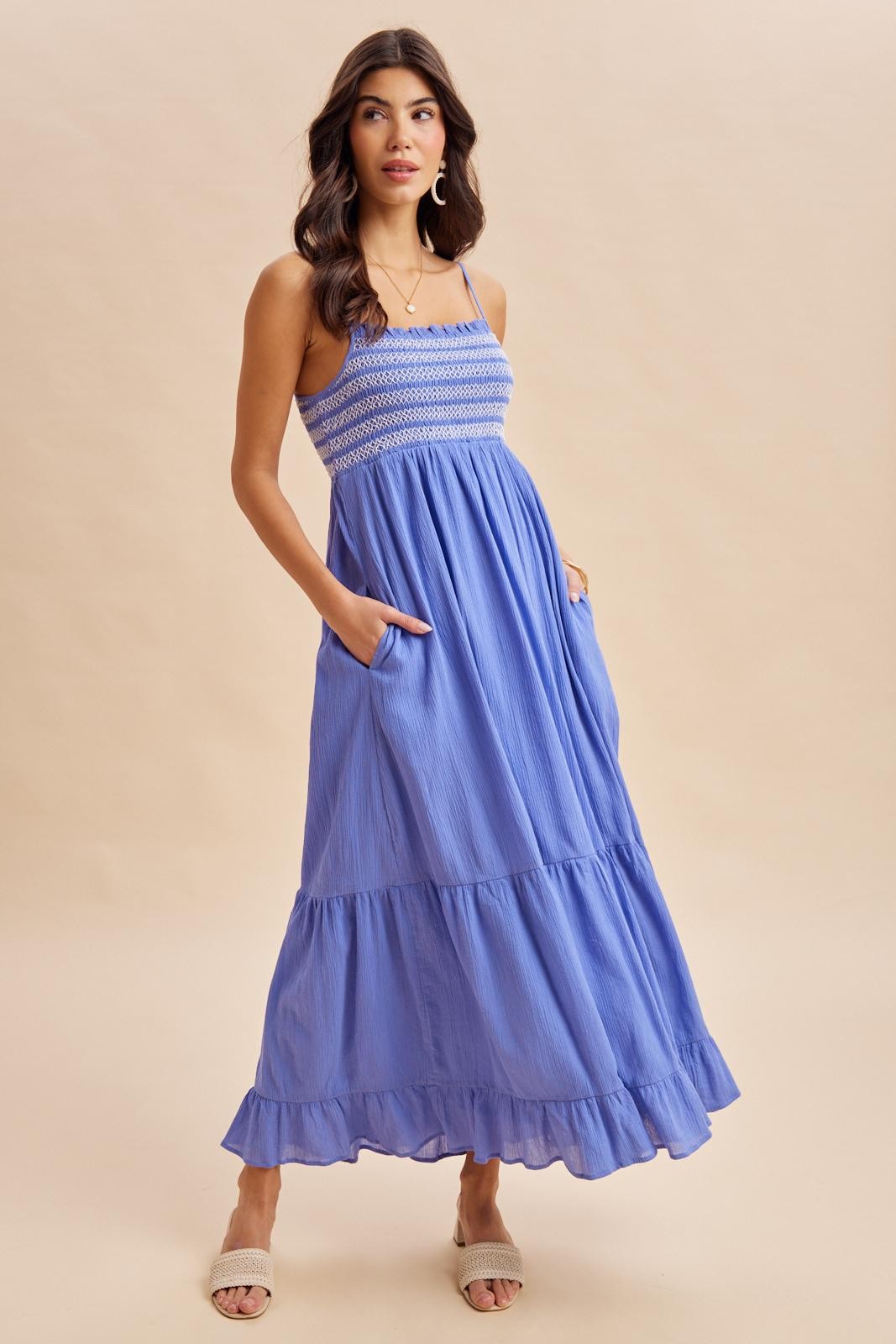 woman wearing a light blue maxi dress with smocked bodice and ruffle hem, featuring pockets