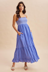 woman wearing a light blue maxi dress with smocked bodice and ruffle hem, featuring pockets
