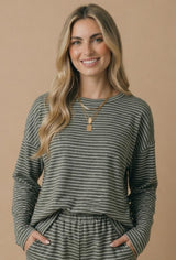 woman wearing a gray striped long sleeve top with a loose fit and relaxed neckline