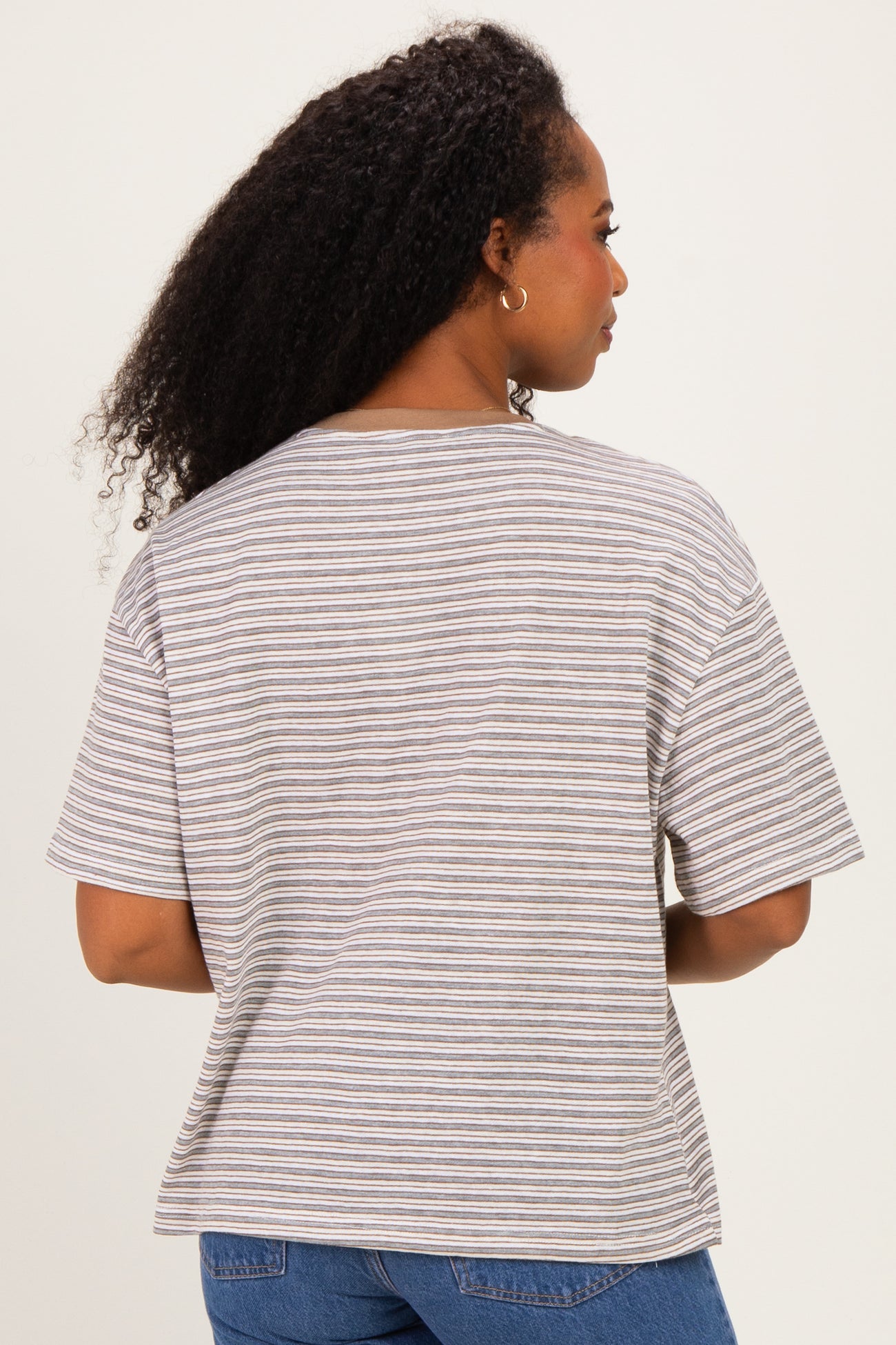 woman wearing a striped short sleeve top with a relaxed fit, showing the back view