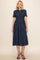 woman wearing a navy blue striped midi dress with a smocked waist and short sleeves
