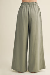 woman wearing loose-fitting olive green wide leg pants with an elastic waistband and side pockets
