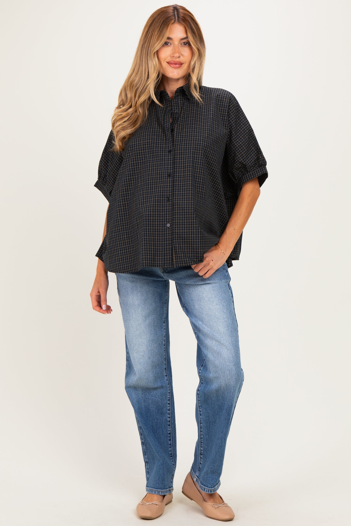 woman wearing a black and checkered maternity shirt with short sleeves and blue jeans
