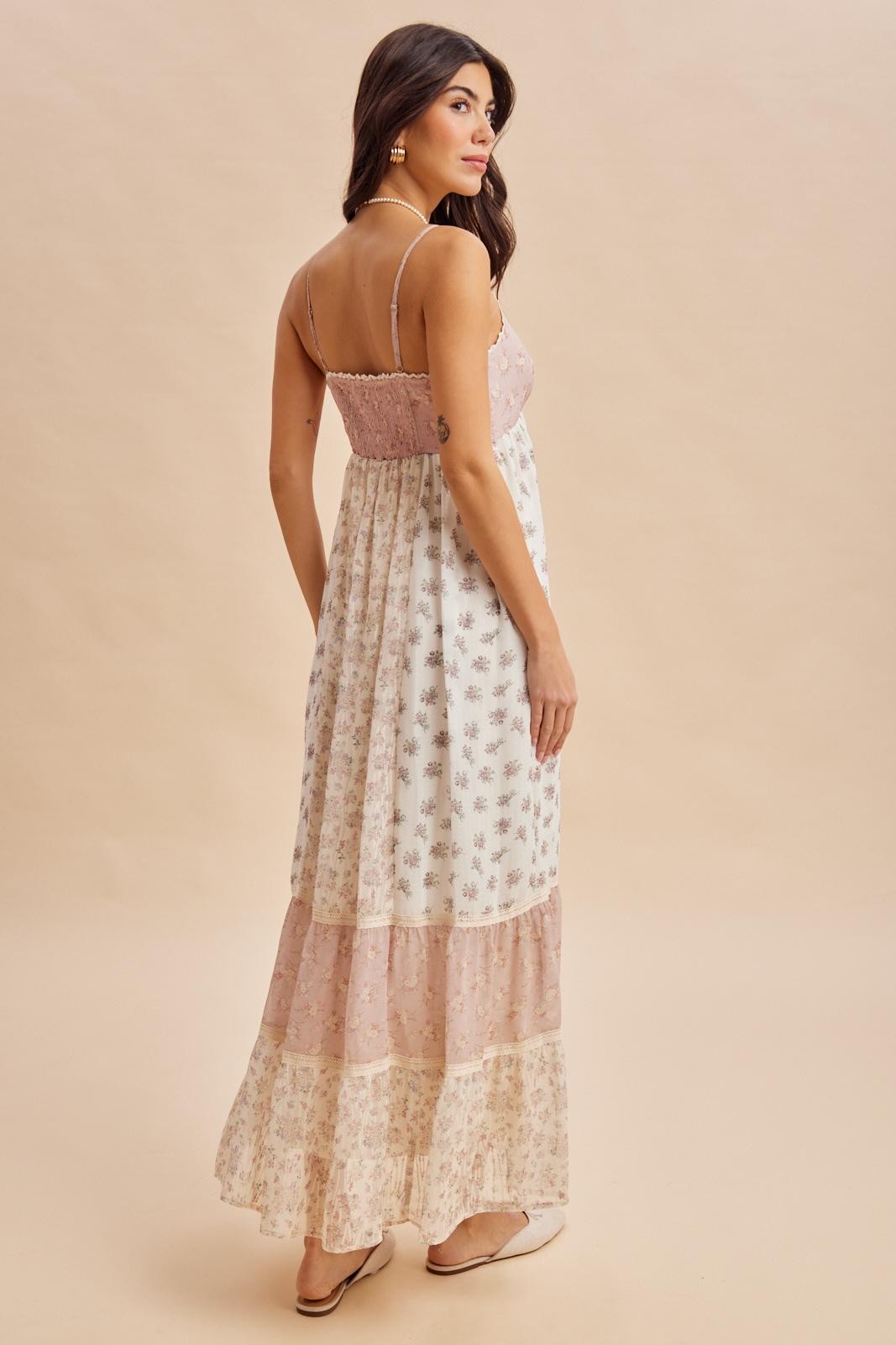 woman wearing a floral maxi dress with a pink bodice and tiered patterned skirt