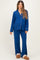 woman wearing a royal blue maternity pajama set with white piping and a visible baby bump