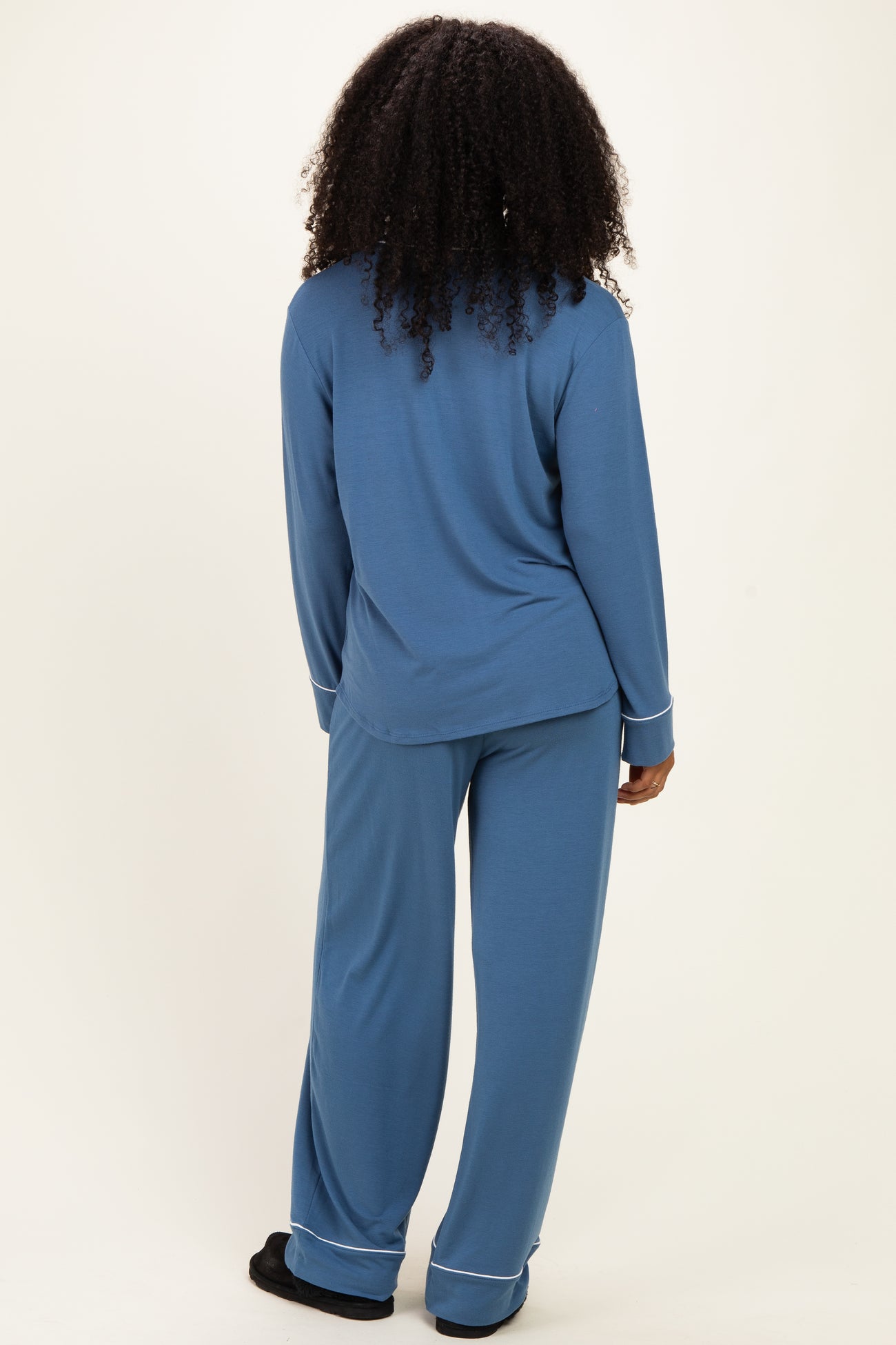woman wearing a blue long sleeve pajama top and matching pajama pants, viewed from the back