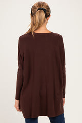 woman wearing a dark brown oversized maternity sweater with long sleeves, viewed from the back