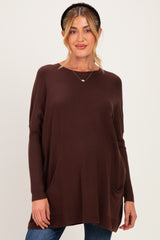 woman wearing a brown maternity sweater with side pockets and a relaxed fit