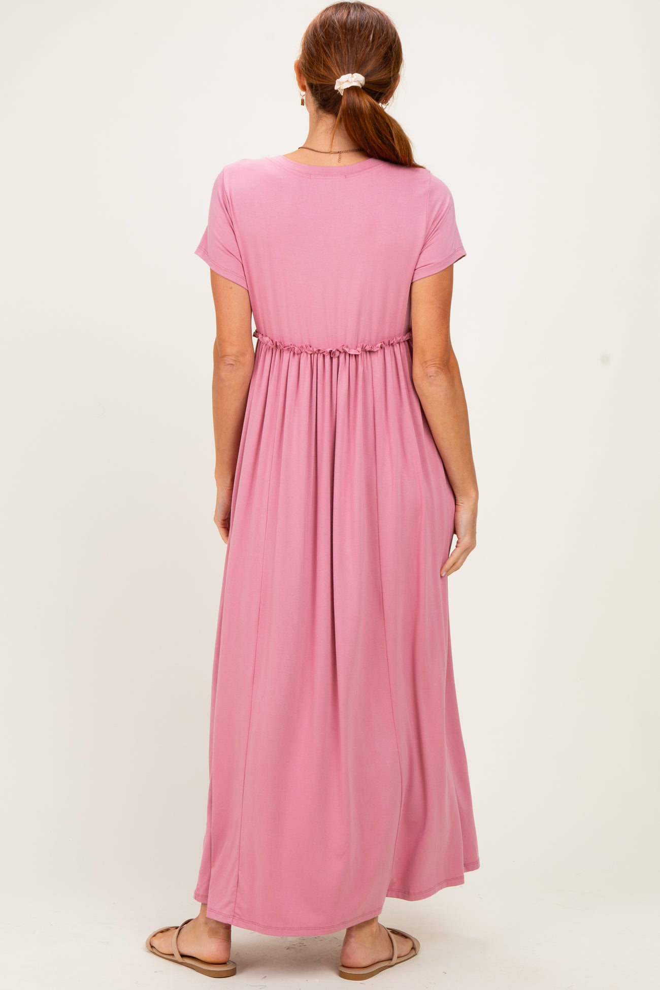 woman wearing a pink short sleeve maxi dress with an elastic waist from the back