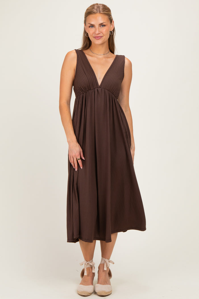 woman wearing a chocolate brown sleeveless maxi dress with a deep v-neck and flowy skirt