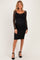 woman wearing a black lace long sleeve maternity dress with a keyhole detail and fitted silhouette, showing her baby bump