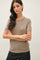 woman wearing a taupe short sleeve knit sweater with a classic crew neck and relaxed fit