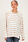 woman wearing a cream and caramel striped maternity top with a relaxed fit and visible baby bump