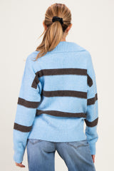 woman wearing a light blue striped maternity sweater with brown stripes, shown from the back