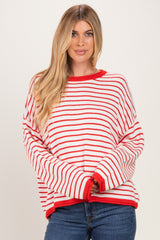 woman wearing a red and white striped oversized sweater with long sleeves and a round neckline