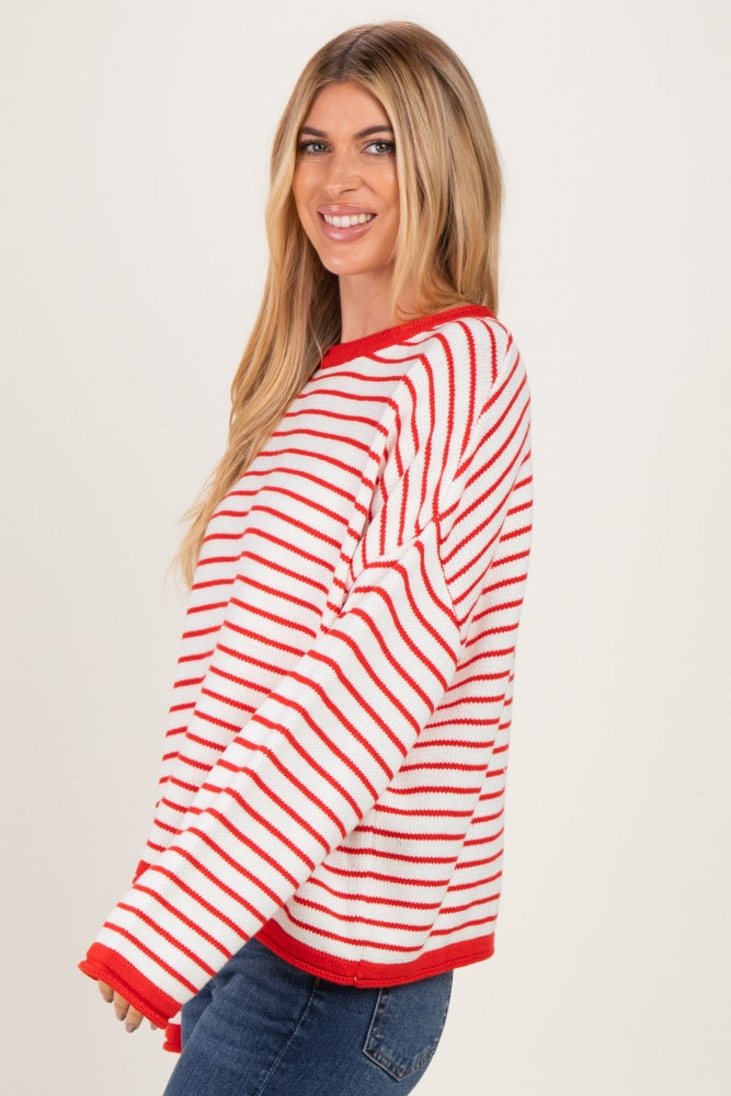 woman wearing a red and white striped oversized sweater with long sleeves and a relaxed fit